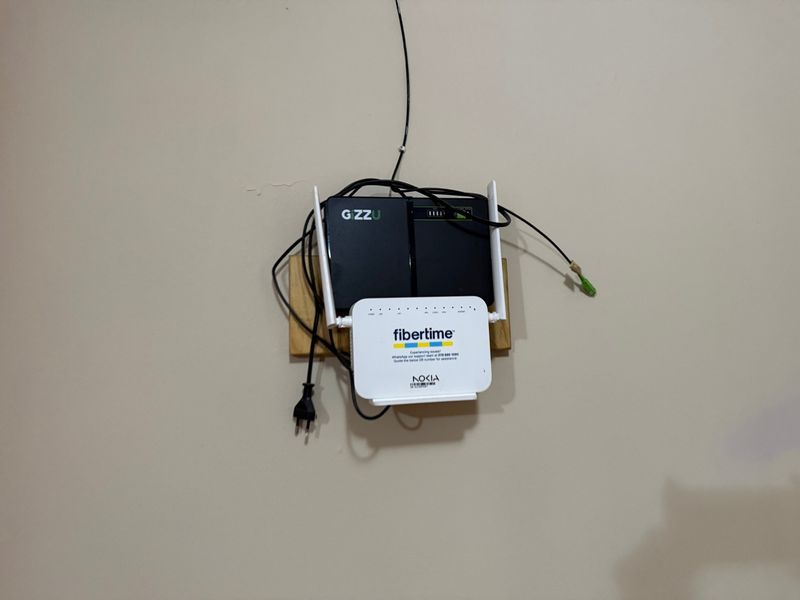 Wall-mounted internet router and power backup unit with exposed cabling.