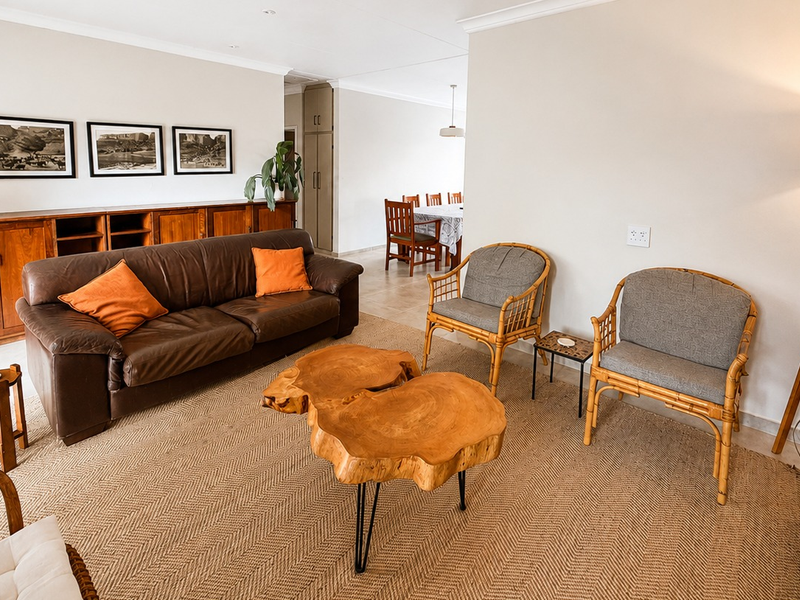 Spacious open-plan living area featuring neutral walls, tiled flooring, and built-in cabinetry, seamlessly connecting to the dining space.
