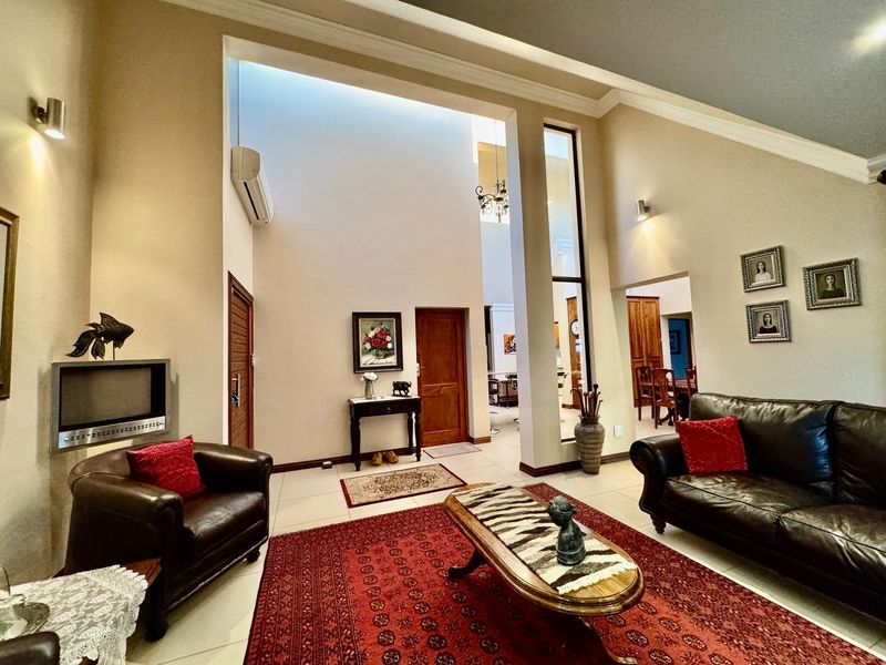 Spacious living room featuring high vaulted ceilings, a skylight, tiled flooring, and a built-in fireplace, creating an open and airy atmosphere.