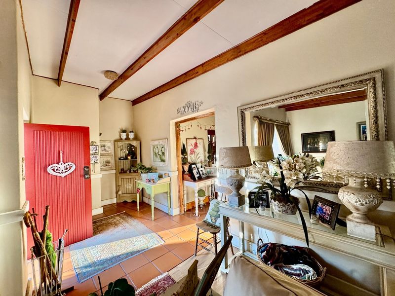 Welcoming entrance hall featuring exposed timber ceiling beams and terracotta floor tiles, providing a warm and characterful transition into the home.