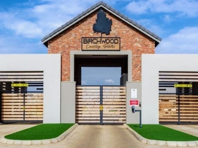 The secure entrance gate to Birchwood Country Estate, featuring a modern brick and render facade with integrated access control and security fencing.