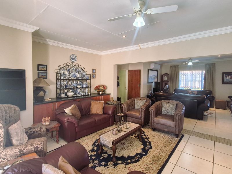 Spacious open-plan living area featuring tiled flooring, recessed lighting, ceiling fans, and built-in cabinetry, offering a versatile layout for comfortable family living.