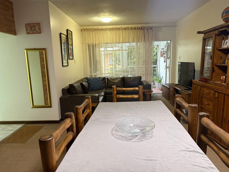 Open plan living and dining area featuring carpeted flooring and a sliding glass door providing access to an outdoor patio space.