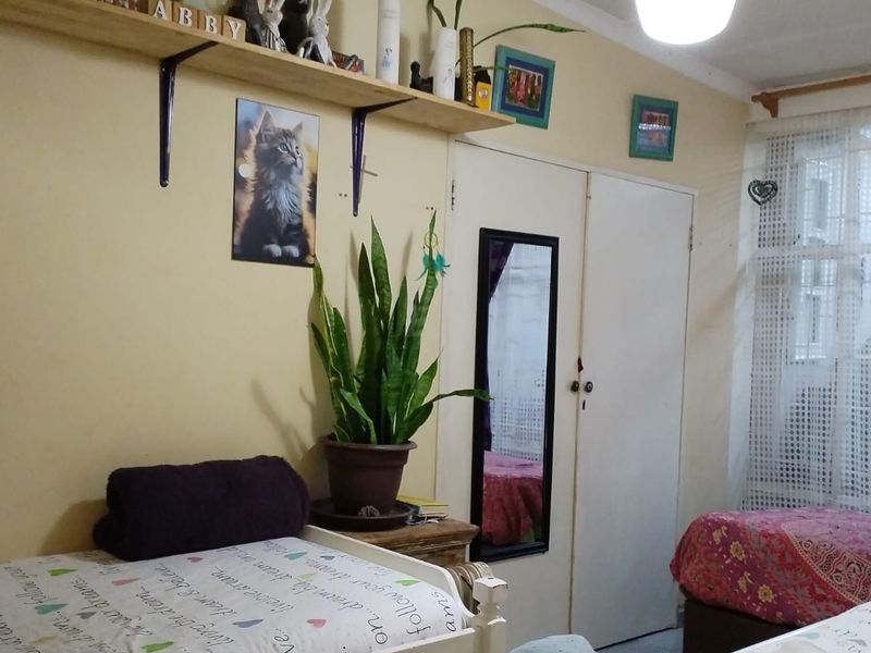 A bedroom featuring built-in cupboard storage and wall-mounted shelving, providing functional space for personal items.