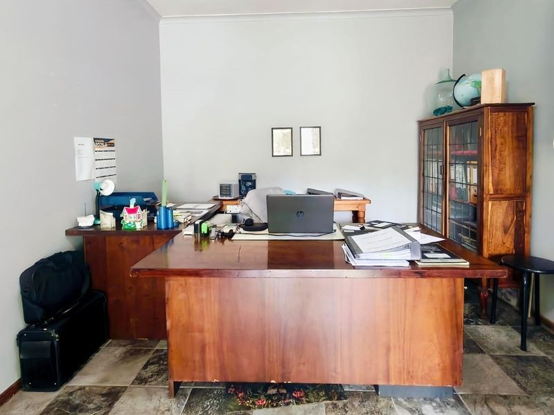 A functional home office space featuring tiled flooring and neutral wall finishes, providing a dedicated area for work or study.