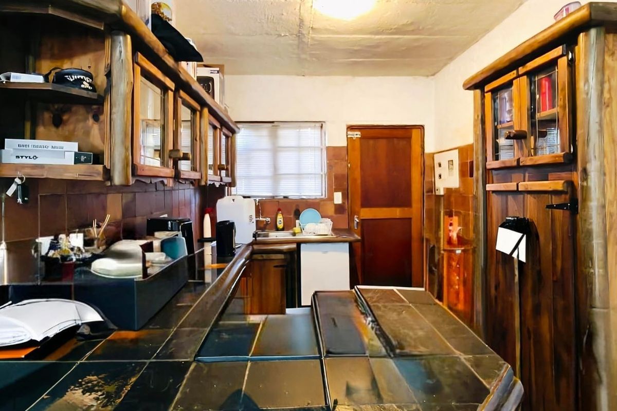 A dated kitchen featuring extensive wooden cabinetry, tiled countertops, and a tiled backsplash, offering a functional layout with potential for modern renovation.