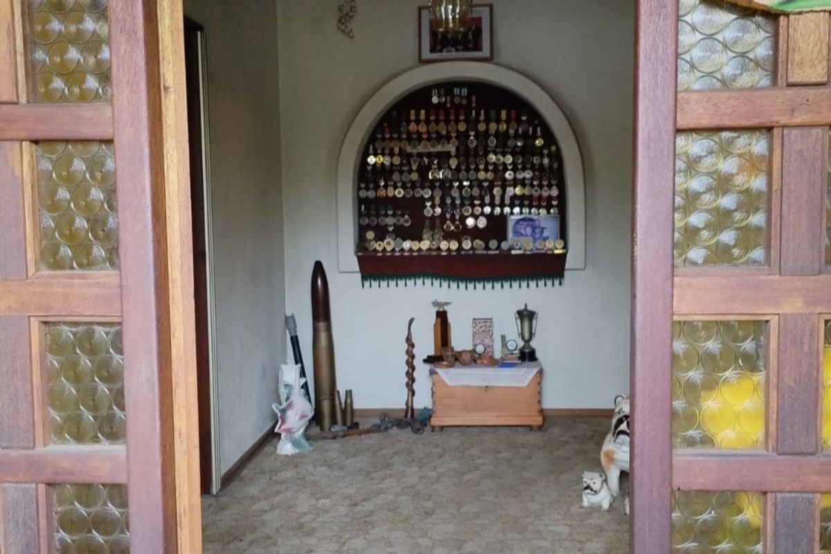 A living area featuring a distinctive arched wall niche and traditional timber-framed glass doors, providing a unique architectural focal point.