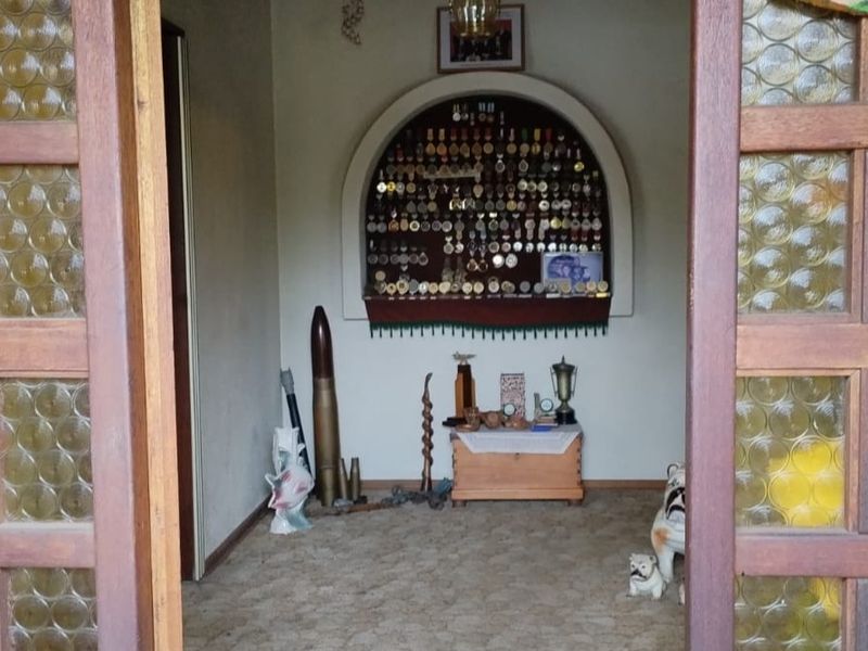 A living area featuring a distinctive arched wall niche and traditional timber-framed glass doors, providing a unique architectural focal point.