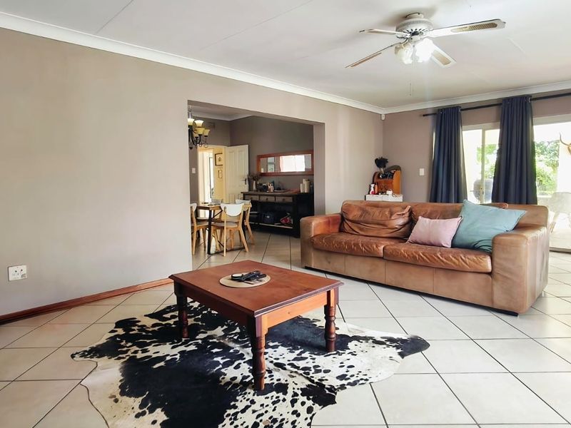 Spacious living room featuring tiled flooring, a ceiling fan, and sliding glass doors that provide access to the outdoor area.
