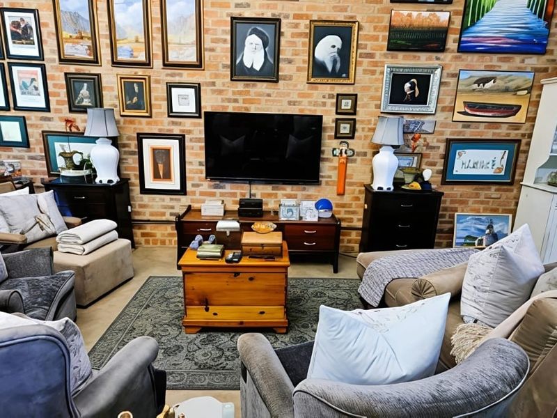 A cozy living room featuring a prominent exposed brick feature wall and built-in storage cabinetry.