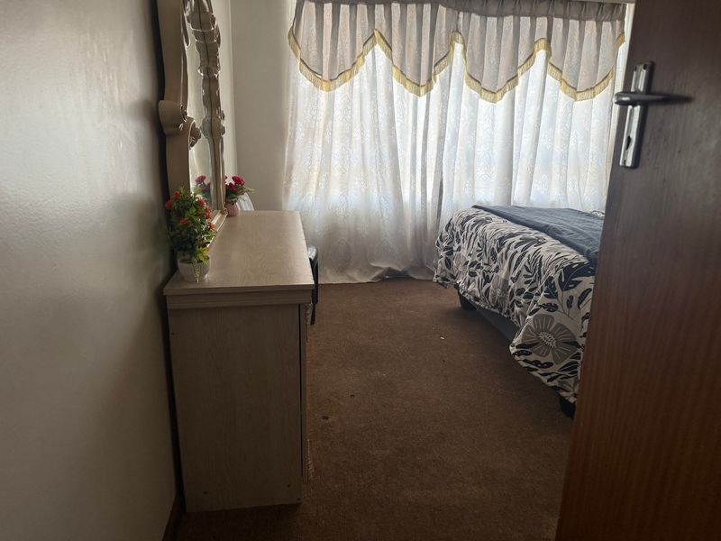 A bedroom featuring carpeted flooring and window treatments, offering a functional space that could benefit from cosmetic updates to enhance its appeal.