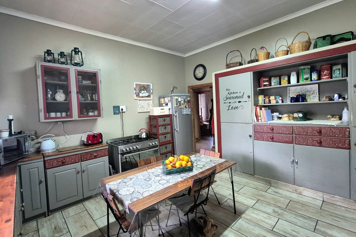 A rustic-style kitchen featuring built-in cabinetry, a gas stove, and tiled flooring, offering a functional layout with ample storage space.