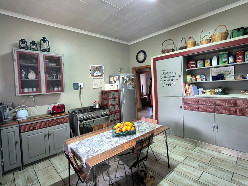 A rustic-style kitchen featuring built-in cabinetry, a gas stove, and tiled flooring, offering a functional layout with ample storage space.