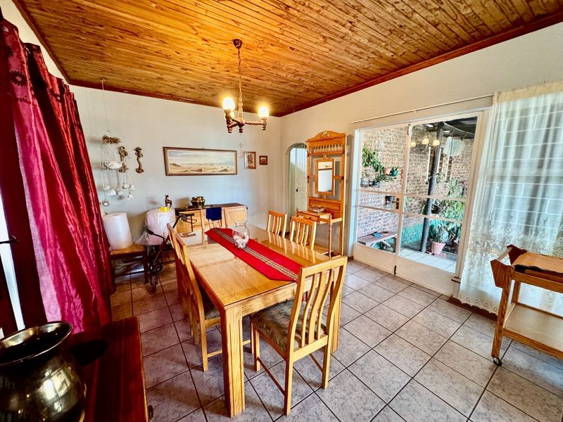 Dining room featuring a timber tongue and groove ceiling, ceramic tiled flooring, and a sliding glass door providing access to the outdoor area.