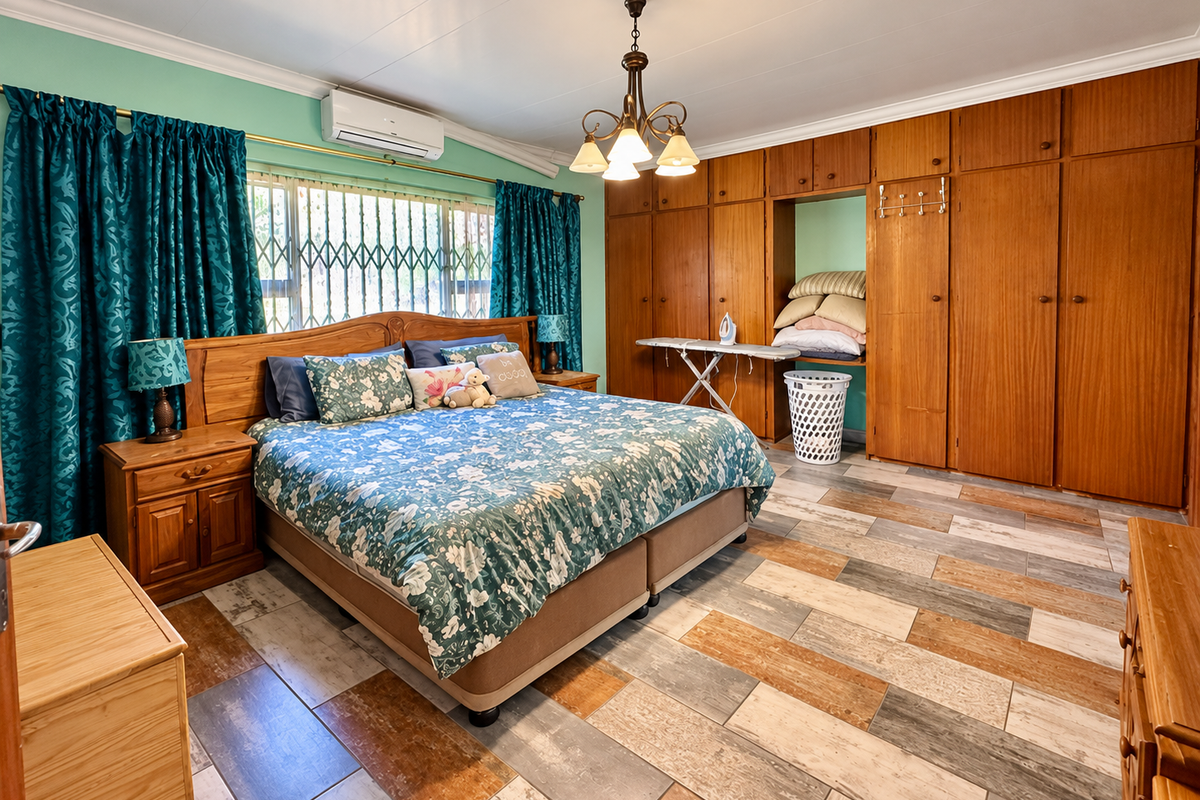 Spacious bedroom featuring extensive built-in wooden cabinetry, tiled flooring, and a wall-mounted air conditioning unit.