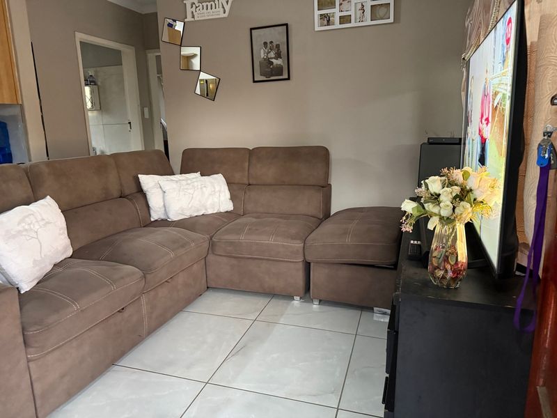 A comfortable living room featuring light-colored tiled flooring and neutral wall tones, providing a functional and well-maintained space for relaxation.