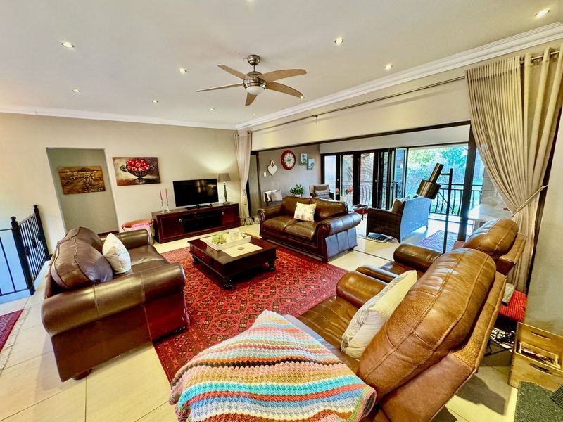 Spacious living room featuring tiled flooring, recessed lighting, a ceiling fan, and large sliding glass doors that open to an outdoor patio area.