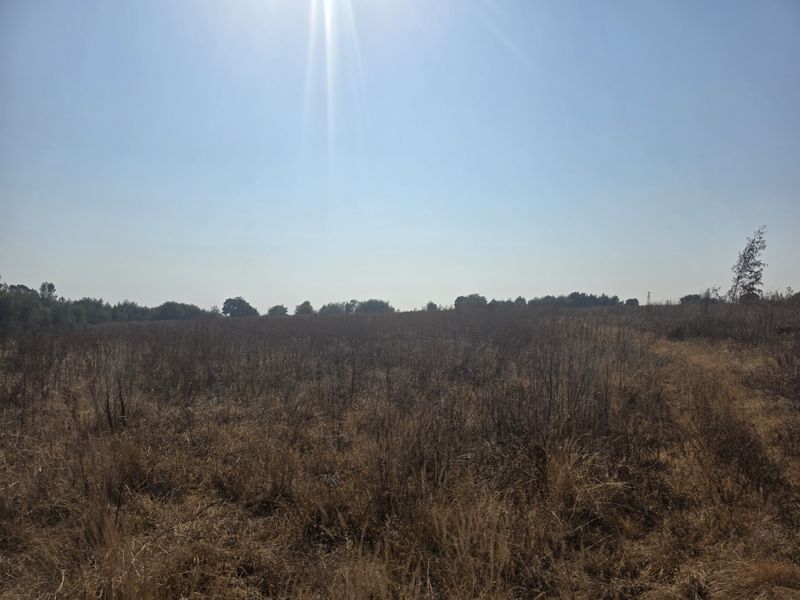 An expansive view of the open farm landscape under a clear blue sky.