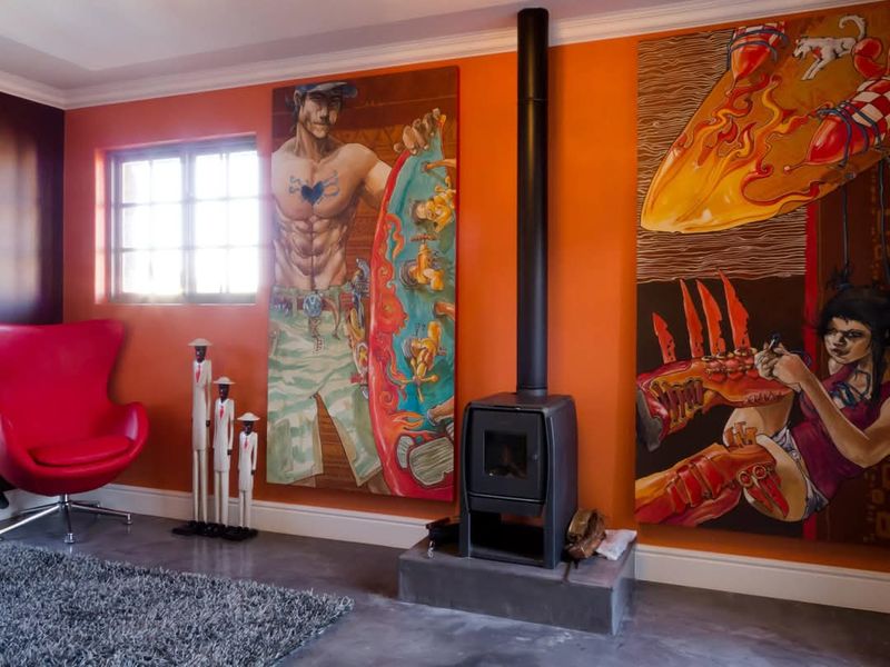 A living room featuring a modern freestanding fireplace on a concrete hearth, polished concrete floors, and decorative crown molding.