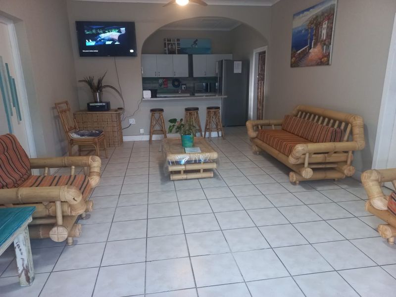 Open plan living area featuring a kitchen with breakfast counter and tiled flooring throughout.