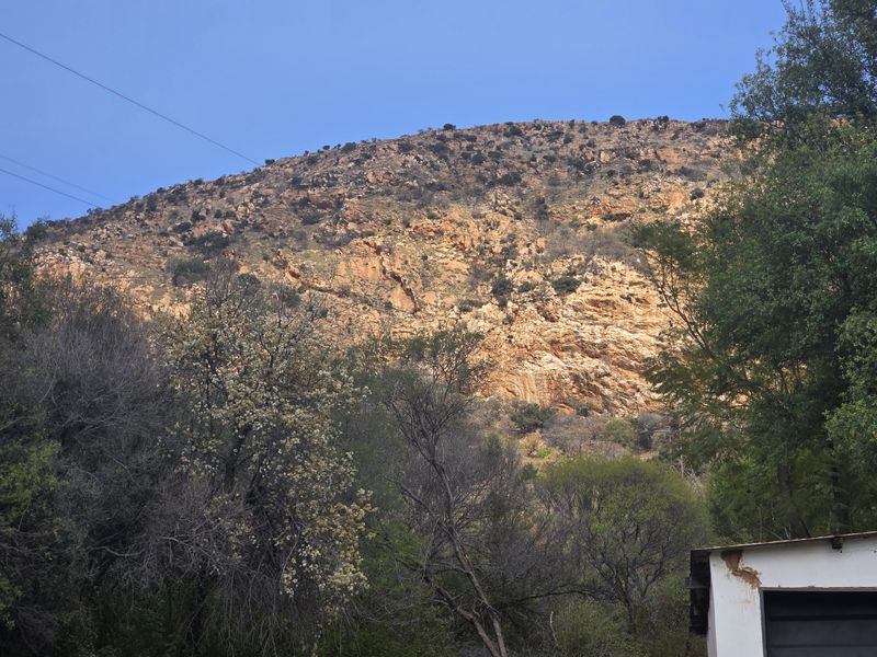 A scenic view of a rugged mountain landscape with natural vegetation and rocky terrain.