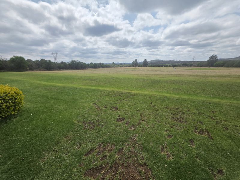 A wide-angle view of the expansive open fields and manicured lawn area on the farm property.
