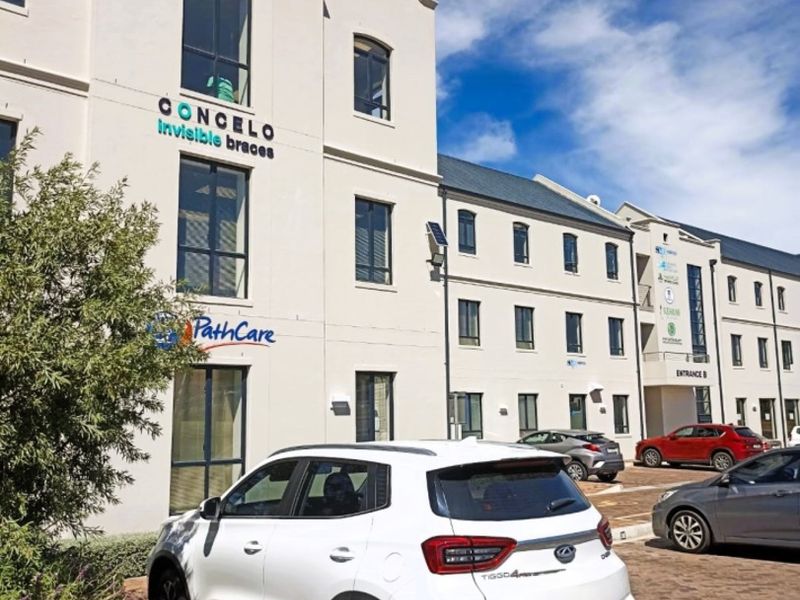 Front exterior view of a multi-story commercial building featuring paved parking and prominent signage for medical and professional tenants.