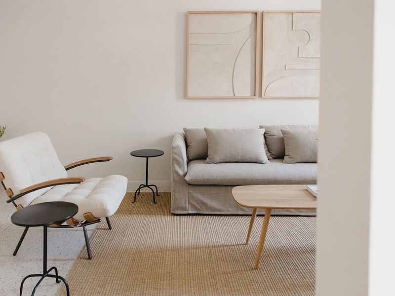 A bright and modern living room featuring neutral tones and high-quality terrazzo flooring, creating a clean and inviting atmosphere.