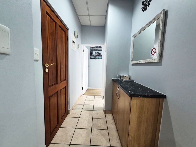 A functional hallway featuring tiled flooring, a built-in storage cabinet with a stone countertop, and a solid wood door.