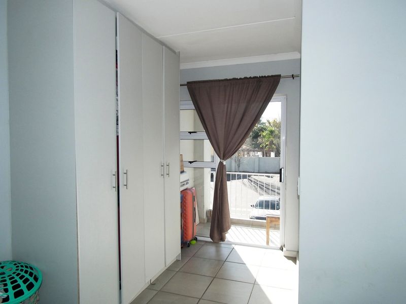 Bedroom featuring built-in cupboards, tiled flooring, and direct access to a private balcony through a sliding glass door.