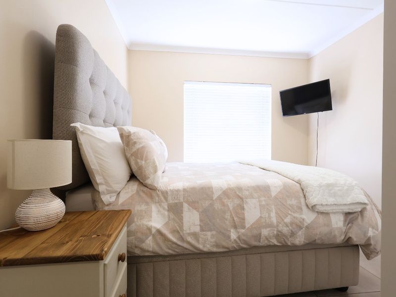 A well-maintained bedroom featuring neutral wall tones, coving, and fitted venetian blinds, providing a clean and comfortable living space.