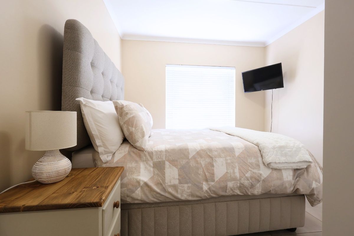 A well-maintained bedroom featuring neutral wall tones, coving, and fitted venetian blinds, providing a clean and comfortable living space.