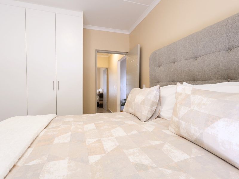 A well-maintained bedroom featuring built-in cupboards and neutral wall finishes, providing a clean and functional living space.