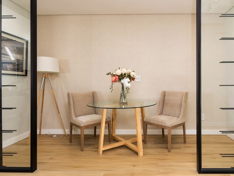 A modern, well-lit office space featuring sleek glass partition walls and high-quality laminate flooring, creating a professional and inviting work environment.