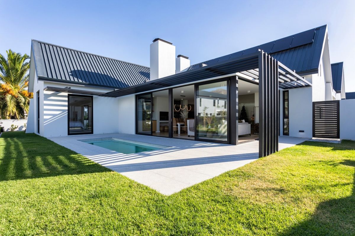 Modern rear exterior featuring a swimming pool, tiled patio, pergola, and large sliding glass doors connecting to the indoor living space.