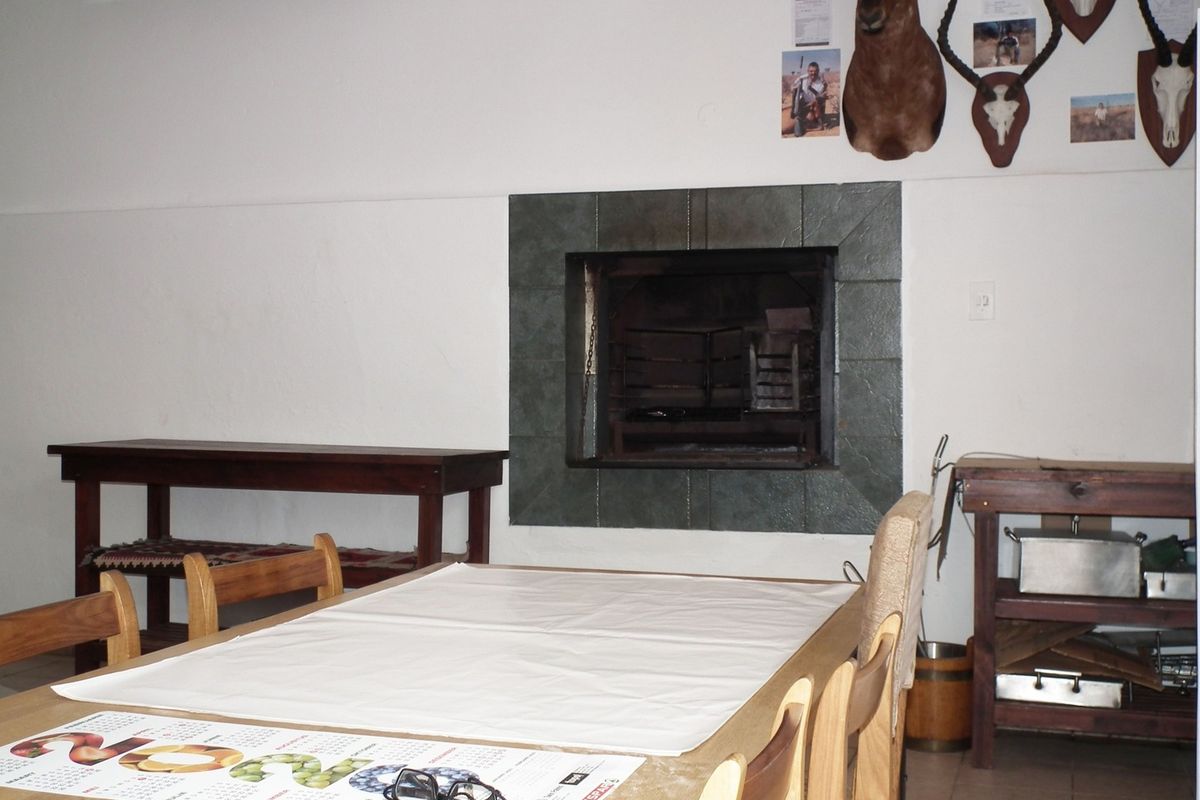 A living area featuring a built-in fireplace with a tiled surround and neutral floor tiles.