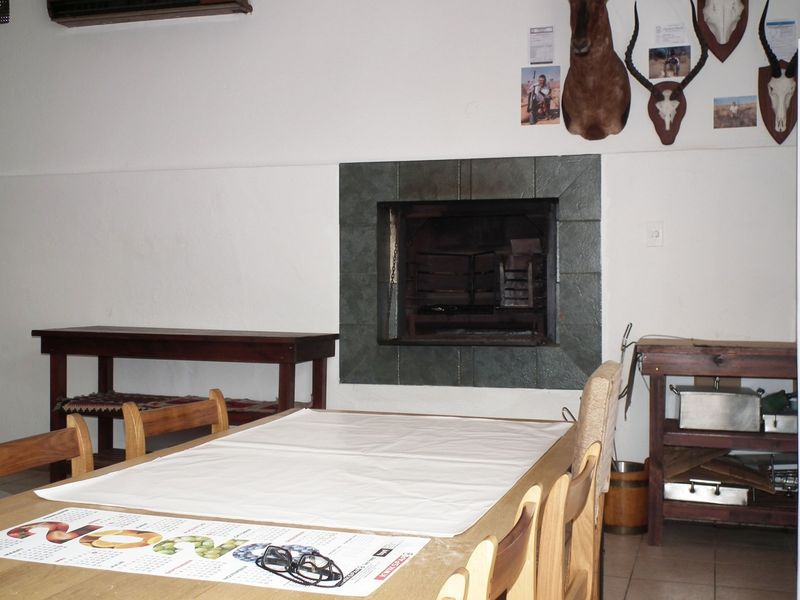 A living area featuring a built-in fireplace with a tiled surround and neutral floor tiles.