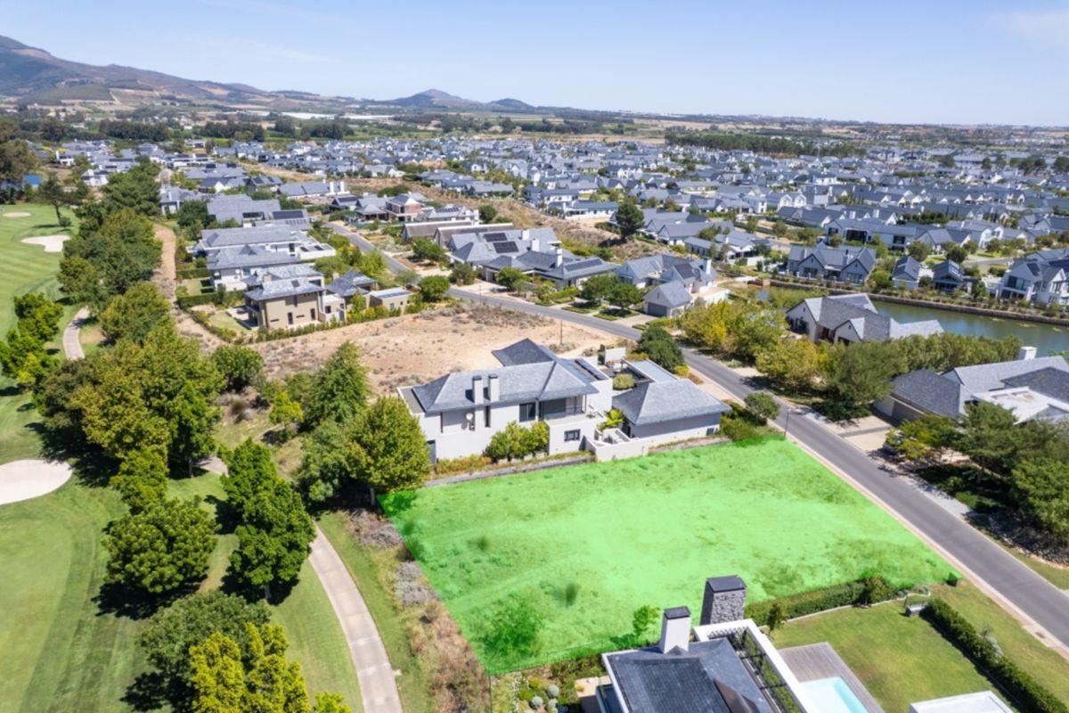 An aerial view of a vacant residential plot situated in a secure estate, featuring direct access to the adjacent golf course.