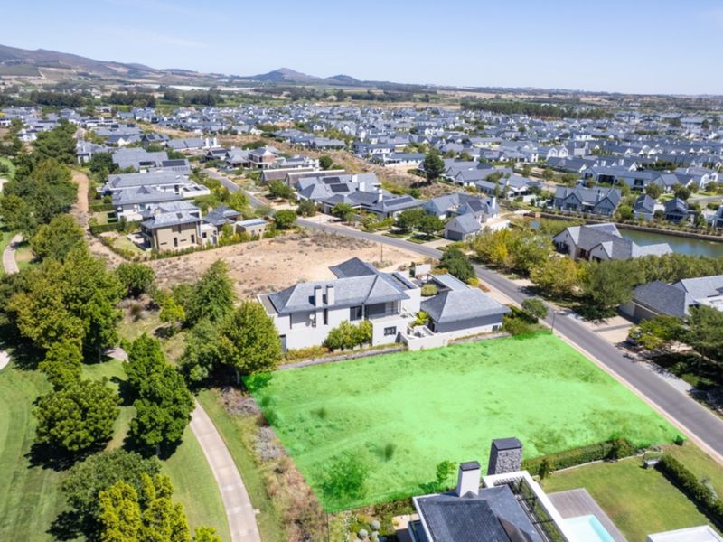 An aerial view of a vacant residential plot situated in a secure estate, featuring direct access to the adjacent golf course.
