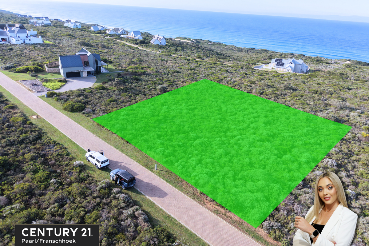 Aerial view of a vacant residential plot situated in a coastal estate, featuring paved road access and proximity to the ocean.