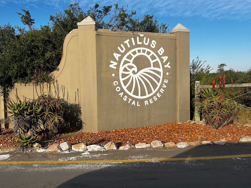 Entrance signage for Nautilus Bay Coastal Reserve, featuring a masonry wall and landscaped garden bed.