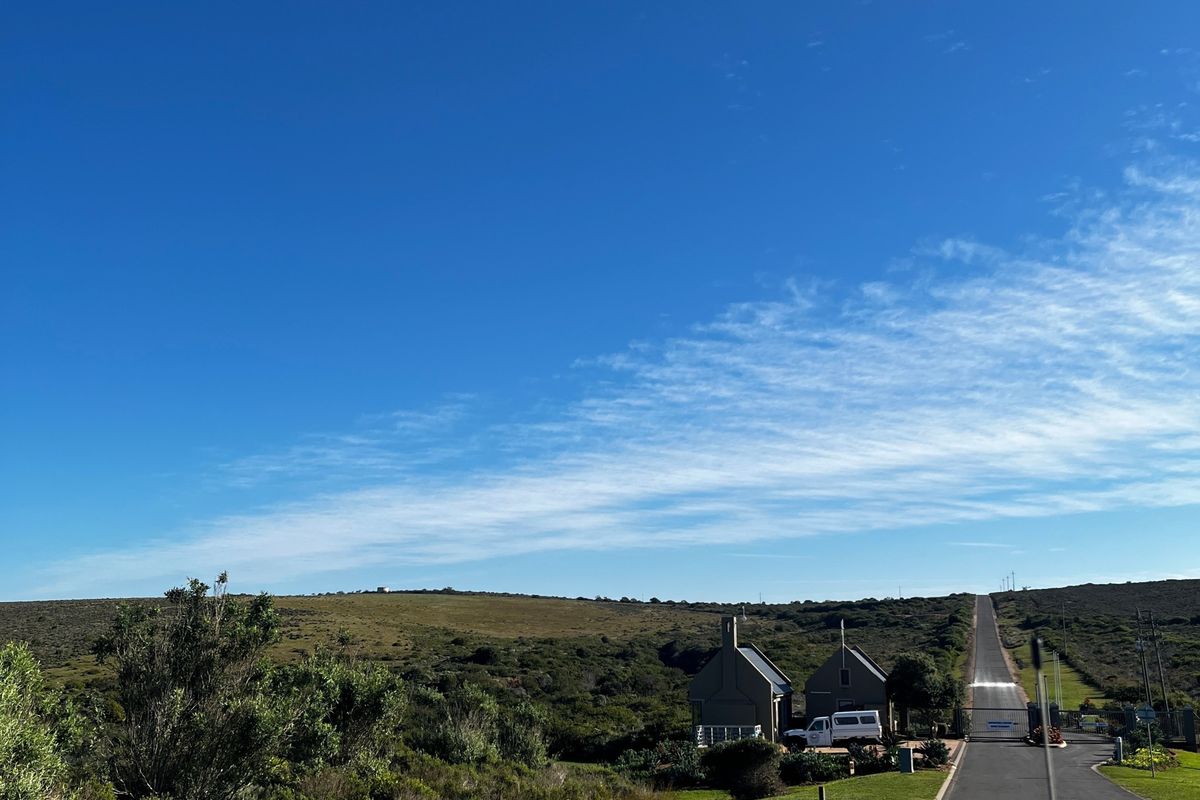 A view of the paved access road leading through the natural landscape towards the property entrance.