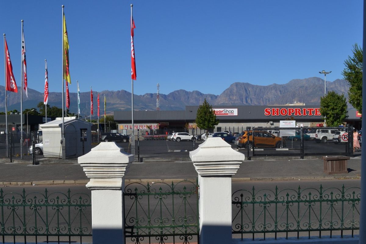 View from the property looking across the street towards a commercial shopping center and mountain range backdrop.
