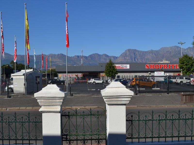View from the property looking across the street towards a commercial shopping center and mountain range backdrop.