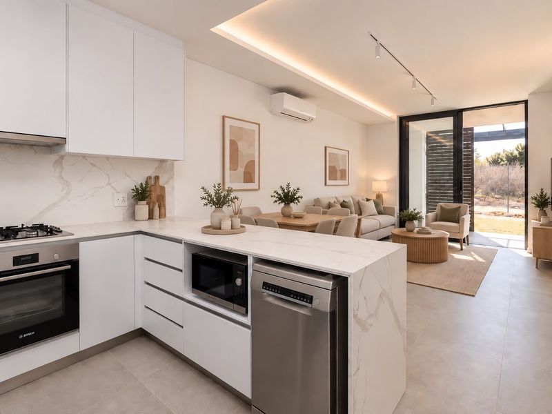 Modern open-plan kitchen and living area featuring sleek white cabinetry, stone countertops, integrated appliances, and seamless access to an outdoor patio space.