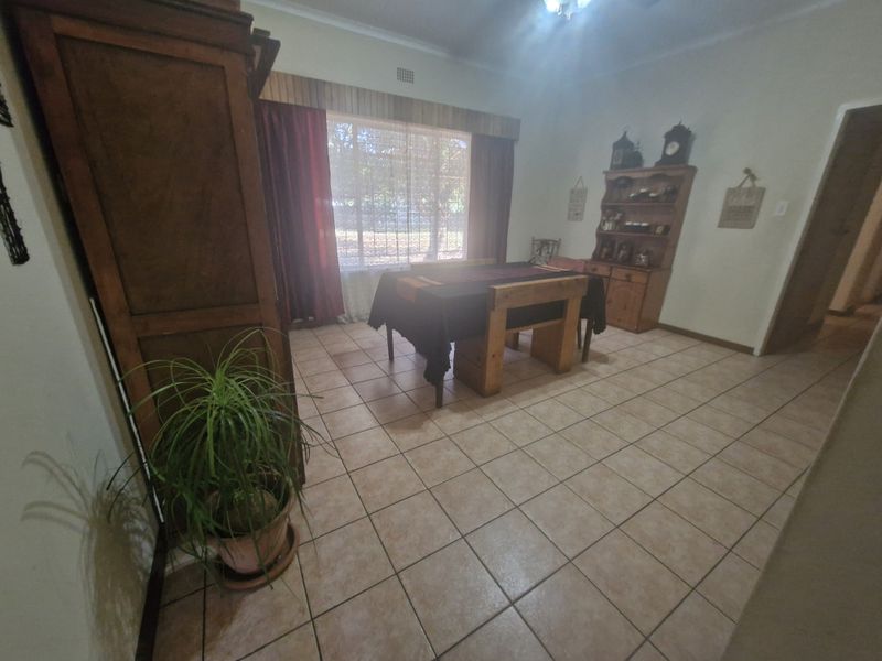 A dining room featuring ceramic tile flooring, a window with a wooden pelmet, and classic cornice detailing.