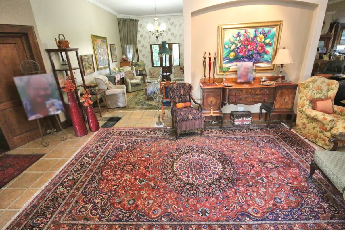 Spacious living area featuring tiled flooring, decorative archway, and traditional interior finishes, connecting to an adjacent lounge space.