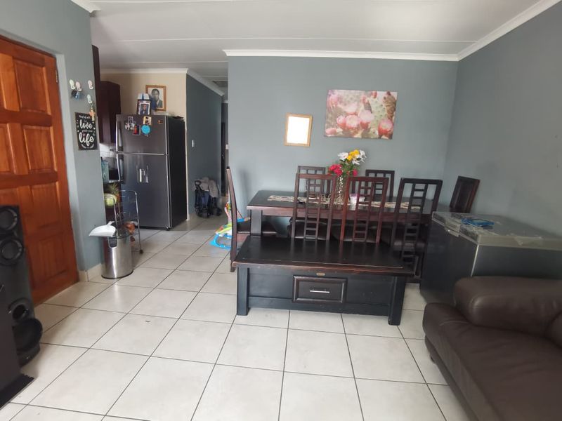 Open plan living and dining area featuring tiled flooring and neutral wall finishes, providing a functional space for daily living.