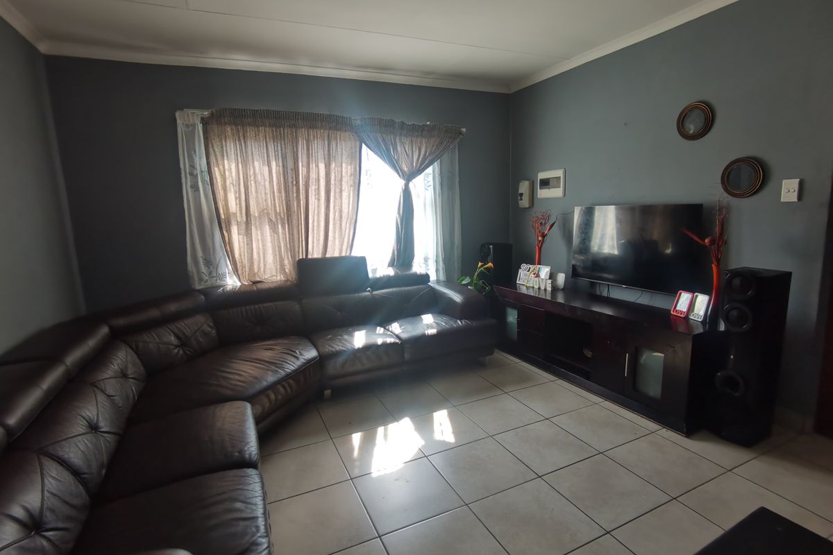 A living room featuring tiled flooring and dark grey walls, providing a functional space for relaxation.