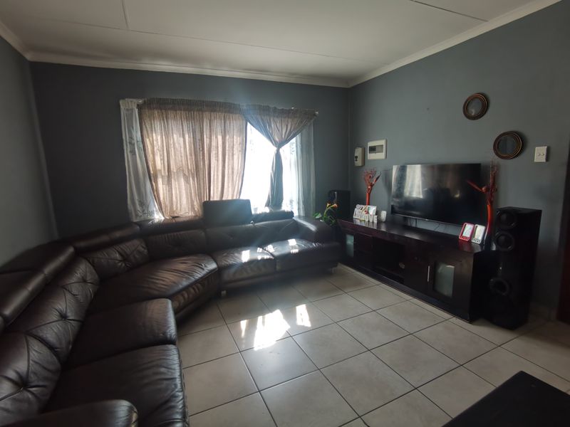 A living room featuring tiled flooring and dark grey walls, providing a functional space for relaxation.